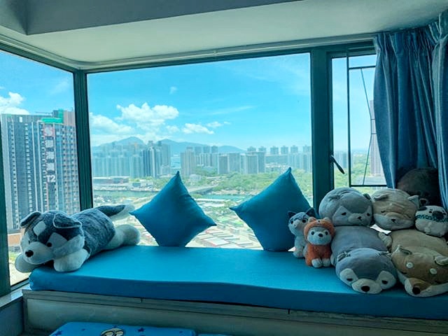 Blue custom baywindow seat with matching cushions in a high-rise flat