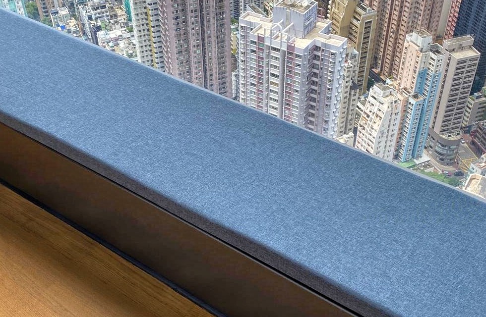 Blue-grey custom cushion fitted to a city-view baywindow