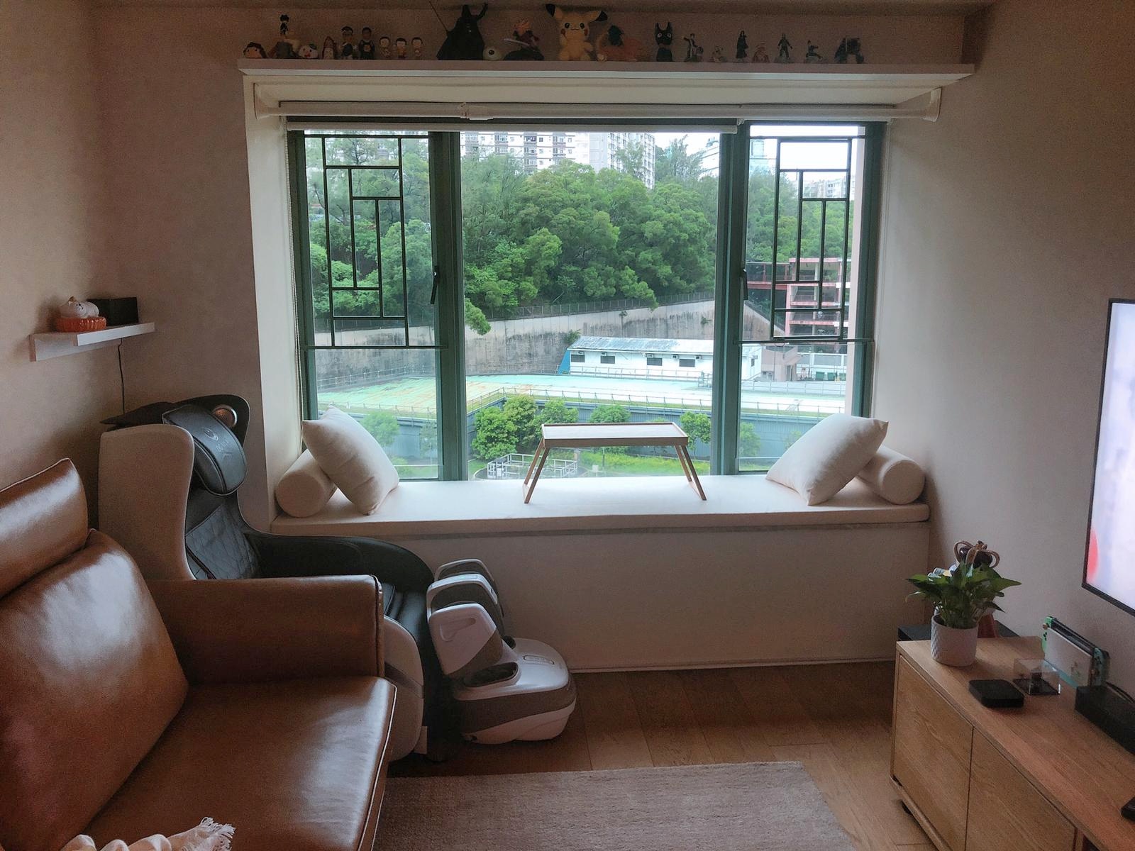 Cream custom baywindow seat with bolsters on a living-room window sill
